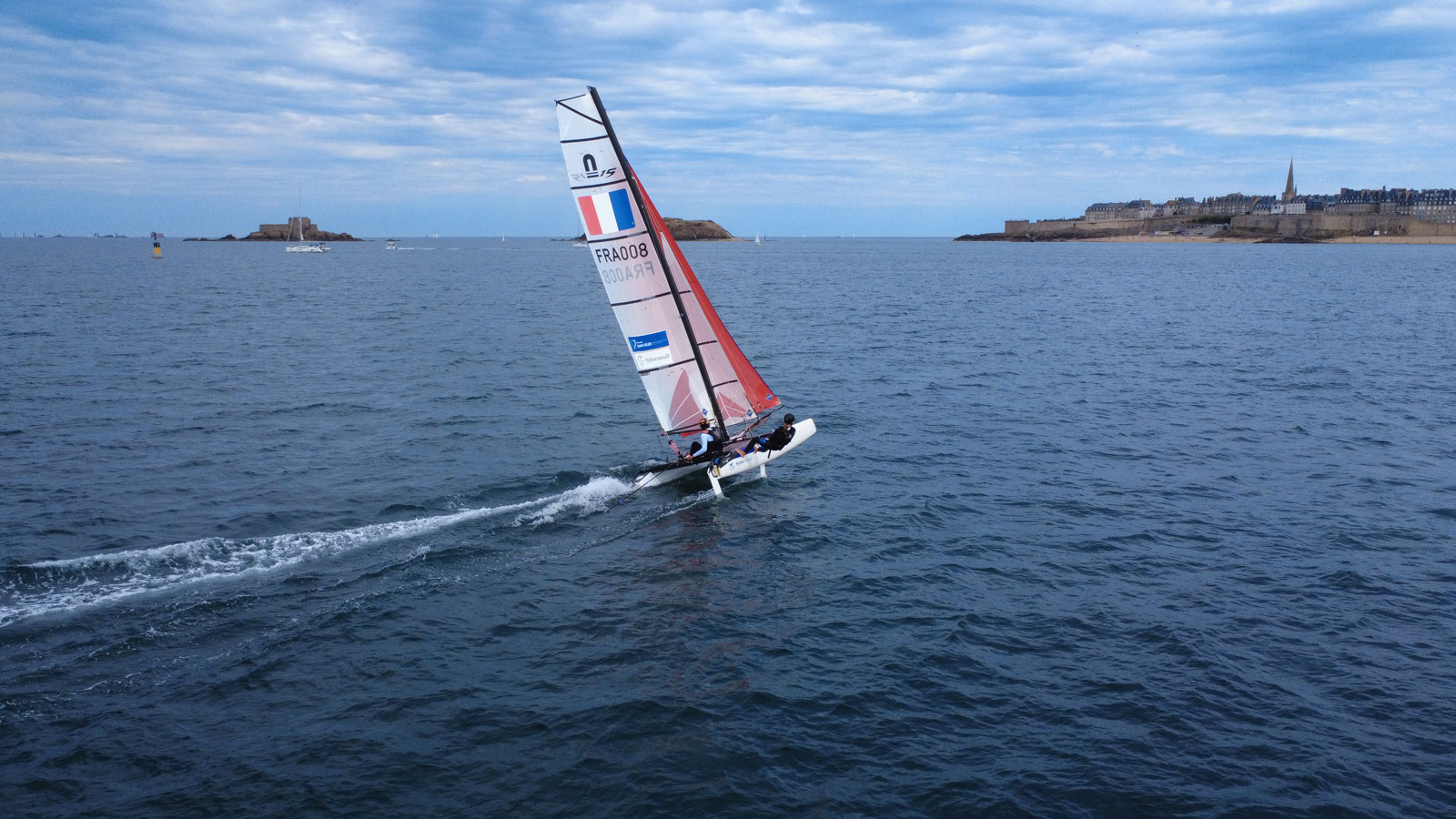Vue aérienne du Nacra 15 FRA008 lancé à pleine vitesse en baie de Saint-Malo Vue aérienne du Nacra 15 FRA008 lancé à pleine vitesse en baie de Saint-Malo